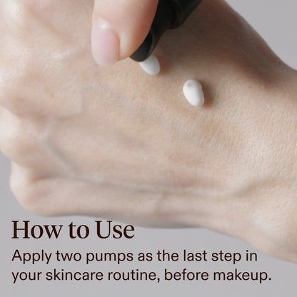 Close-up of a hand with two small white dots of cream being dispensed from a black pump, with text reading 'How to Use: Apply two pumps as the last step in your skincare routine, before makeup.'.