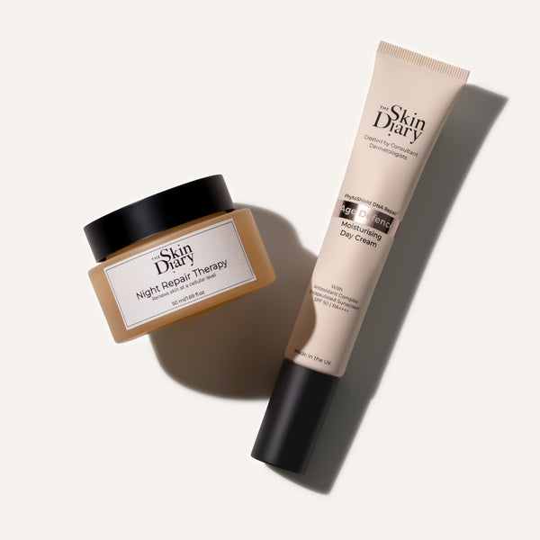 Skin Diary skincare set featuring a Night Repair Therapy jar and an Age Defence Day Cream tube, arranged diagonally on a clean white background with soft shadows.